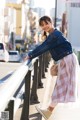 A woman leaning on a railing on a city street.